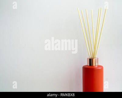 Lufterfrischer stick rot Flasche auf weiße Wand Hintergrund mit kopieren. Aromatische reed Stick in modernen Flasche. Stockfoto