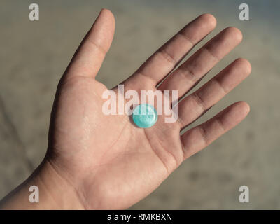 Blau husten Tropfen in die Hand. Raute Halsschmerzen. Stockfoto