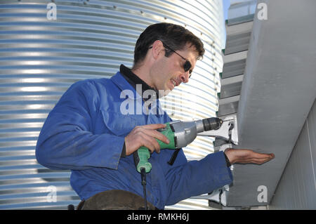 Ein Klempner anbringen, Dachrinnen, ein Geschäftshaus Stockfoto