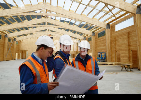 Drei Bauherren diskutieren den Plan für einen großen Bau job Stockfoto