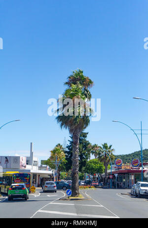 MOUNT MAUNGANUI NEUSEELAND - 8. FEBRUAR 2019: Maunganui Straße in der Haupteinkaufsgegend Palmen mit vorbeifahrenden Fahrzeuge und Menschen, Stockfoto