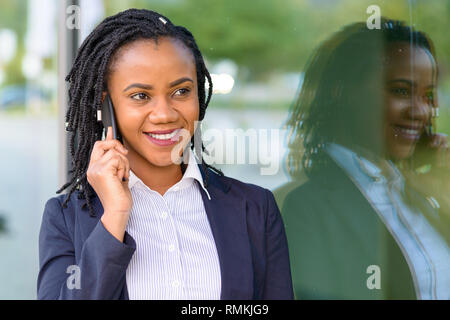 Outdoor Portrait von lächelnden elegante Afrikanische amerikanische Frau am Telefon sprechen Stockfoto