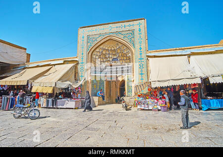 ISFAHAN, IRAN - 21. Oktober 2017: Die reich verzierten Portal der mittelalterlichen Jameh Moschee Nachbarn mit Großen Basar Läden und Ständen, am 21. Oktober in Isfahan. Stockfoto
