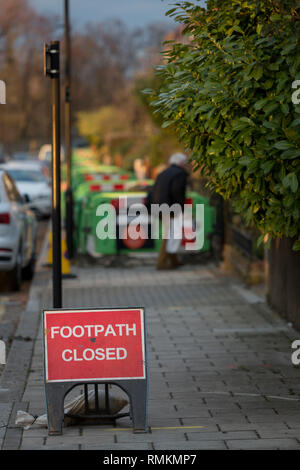 Aufgrund der Arbeiten von Fremdfirmen im Namen des Gasnetzes SGN durchgeführt, Kunststoff Hemmnisse blockieren den Bürgersteig entlang Ferndene Straße in Herne Hill SE24, am 11. Februar 2019 in London, England. Stockfoto