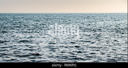 Schönes Foto von relativ ruhigen Meer Oberfläche (Arabische Meer) mit klaren Horizont nur nach Sonnenuntergang. Sonnenuntergang mit einer magischen Tönung der Wasser Farbe. Stockfoto