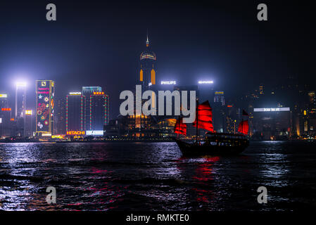 Hongkong - Dezember 8, 2013: Beleuchtet chinesische rote Junk (aqualuna) auf Victoria Harbour und Hong Kong, an einem nebligen Winternacht. Stockfoto