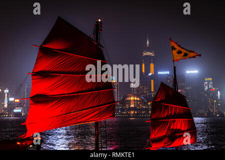 Hongkong - Dezember 8, 2013: Beleuchtet chinesische rote Junk (aqualuna) auf Victoria Harbour und Hong Kong, an einem nebligen Winternacht. Stockfoto