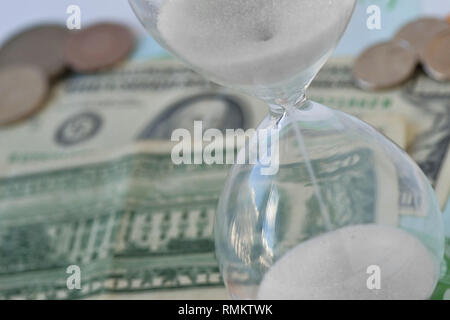 In der Nähe von Sanduhr am Dollar Geld Hintergrund - Begriff der Countdown, Frist und Zeit ist Geld Stockfoto