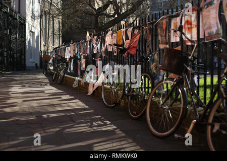 Leihfahrräder sind Geländer außerhalb St Johns College an der Universität Cambridge in der Stadt gesperrt. Stockfoto