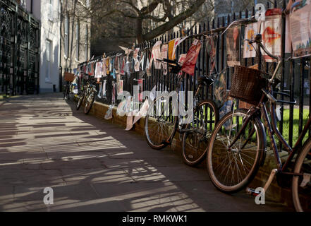 Leihfahrräder sind Geländer außerhalb St Johns College an der Universität Cambridge in der Stadt gesperrt. Stockfoto