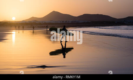 Silhouette einer Surfer am Famara Strand bei Sonnenuntergang, Kanarische Insel Stockfoto