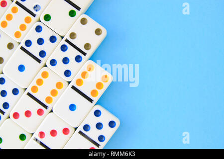 Weiß Dominospiel mit bunten Punkte auf blauem Hintergrund schuss Overhead mit Platz kopieren Stockfoto