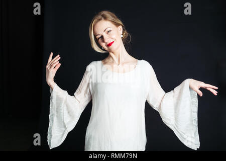 In der Nähe von Studio Porträt der schönen Frau in einem weißen Kleid auf schwarzem Hintergrund Stockfoto