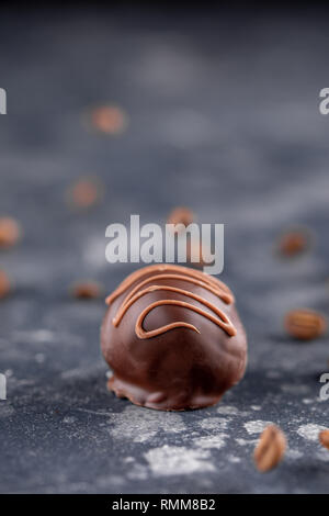 Satz von Luxus Schokolade Bonbons mit Kaffee füllen mit Karamell Spritzer eingerichtet. Exklusive handgemachte Bonbons auf Holz- Hintergrund. Close-up. Stockfoto