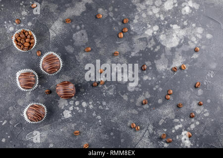 Schokolade Trüffel, Kaffee Bohnen auf einem dunklen Hintergrund. Hausgemachten Süßigkeiten. Ansicht von oben. Stockfoto