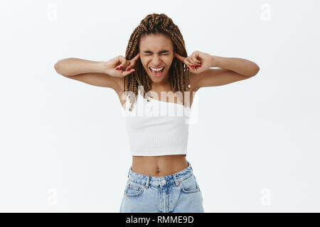 Mädchen Screams von Laute nervige sirene Schließen der Augen und Ohren biegen Kopf unten und das Kreischen von antipathie verlieren Temperament das Gefühl irritiert und displeas Stockfoto