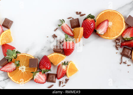 Flach Zusammensetzung eines Mix aus Erdbeeren, orange, Schokolade auf einem hellen Marmorboden Hintergrund Stockfoto