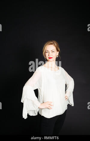 In der Nähe von Studio Porträt der schönen Frau in einem weißen Kleid auf schwarzem Hintergrund Stockfoto