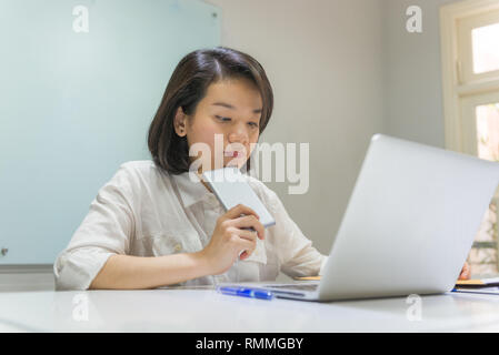 Junge asiatische Büro Frau über die Arbeit denken Stockfoto