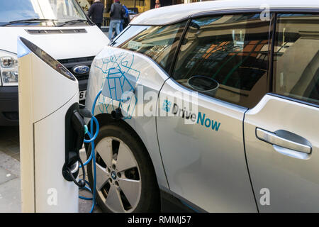 Ein Laufwerk jetzt Car Sharing BMW i3 elektrische Auto an eine Ladestation in Central London geladen wird. Stockfoto
