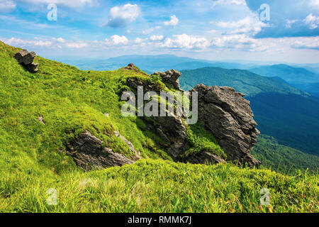 Felsige Klippe auf einem grasigen Hang. schöne Landschaft in den Bergen. Riesige ridge in der Ferne. schönen Sommer Wetter Stockfoto