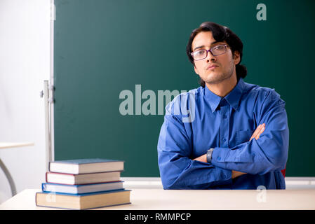 Junge männliche Lehrer vor der Tafel Stockfoto