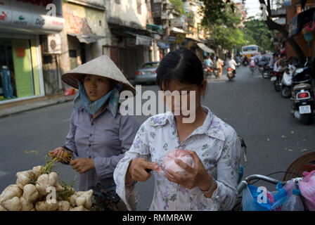 Mädchen in konischer Hut, wandern Vergangenheit vietnamesisches Mädchen peeling pomelo Früchte, Hanoi, Vietnam Stockfoto