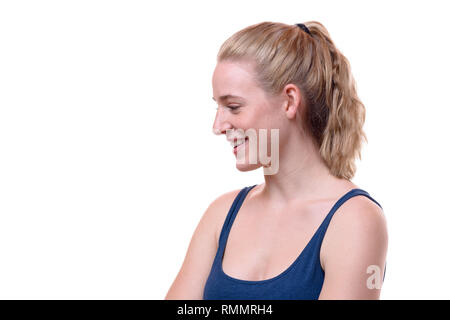 Freundlich lächelnde junge blonde Frau, unten auf der Seite in einem Kopf und Schultern Profil Portrait Suchen auf Weiß Stockfoto