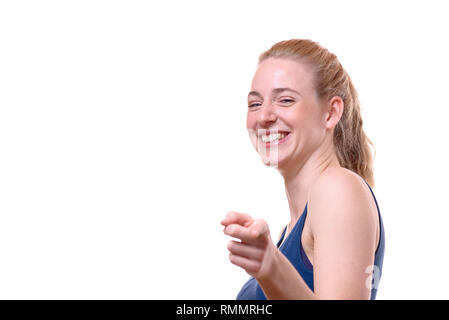 Studio shot Porträt einer fröhlichen schöne junge Frau trägt Ärmelloses oben blau, während die Kamera vor weißem Hintergrund, die für die Kopie sp Stockfoto