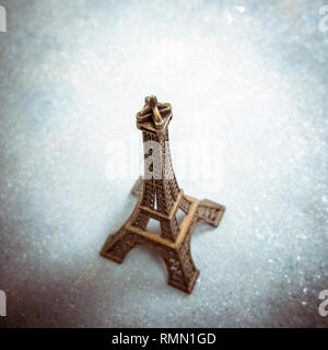 Souvenir Modell des Eiffelturms auf Zementboden. Starke Vignette, Split straffende Wirkung und Filmkorn Filter. Stockfoto