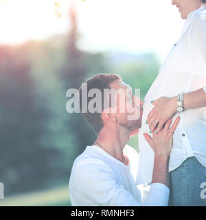 Gerne schwangere Frau mit Mann im Park Stockfoto