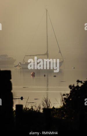 Segelboot auf ruhiger See im Nebel Stockfoto