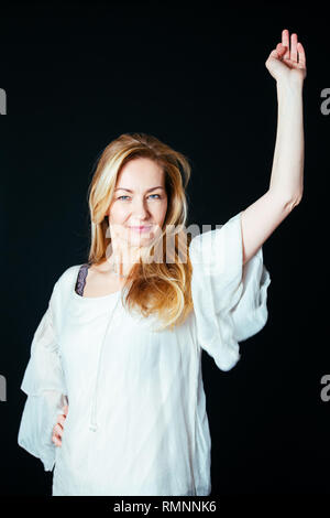 In der Nähe von Studio Portrait einer schönen Frau im weißen Kleid bis auf schwarzem Hintergrund zeigen Stockfoto
