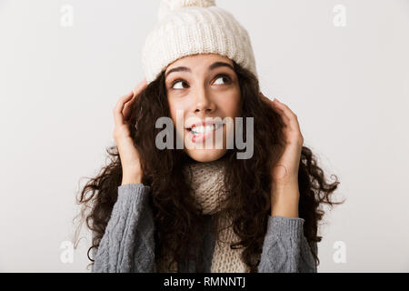 Glückliche junge Frau in Winterkleidung auf weißem Hintergrund stehend Stockfoto