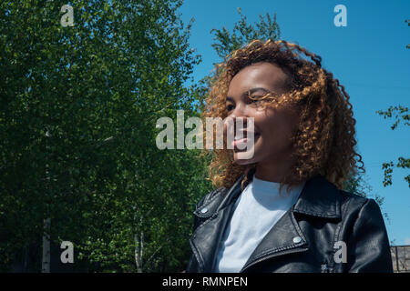 Eine schöne Afrikanische Mädchen geht hinunter die Straße im Frühjahr Stockfoto