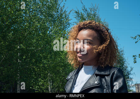 Eine schöne Afrikanische Mädchen geht hinunter die Straße im Frühjahr Stockfoto