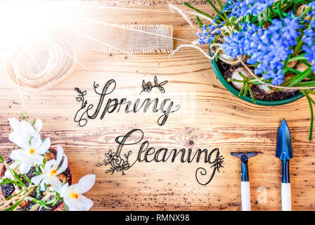Englisch Kalligraphie Frühjahrsputz. Sonnige Frühling Blumen wie Traubenhyazinthen und Krokus. Gartengeräte wie Rechen und Schaufel Stockfoto