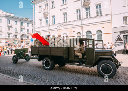 Gomel, Belarus - Mai 9, 2018: Militär-Lkw mit einer Kanone in einem Anhänger und mit Soldaten der Roten Armee im Rücken bewegt sich durch die Straßen der Stadt Gomel auf Sieg Tag 9. Stockfoto