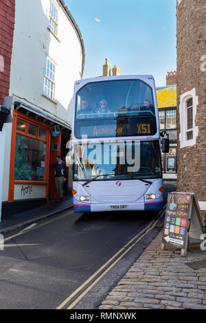 Ein Doppeldecker-bus drückt durch die engen Gassen von Lyme Regis in Großbritannien an einem sonnigen Tag Stockfoto