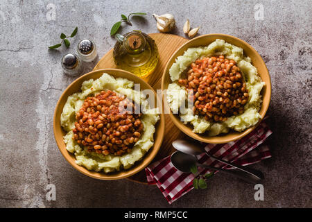 Kartoffelpüree mit gedünstetem weiße Bohnen in Tomaten. Winter wärmende Rezept von veganen Küche Stockfoto