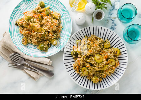 Feder Risotto auf einem Marmortisch mit Gewürzen und Olivenöl Stockfoto