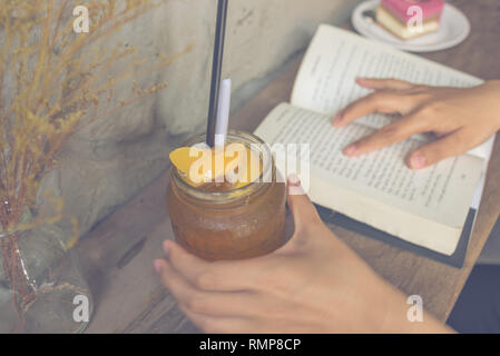 Junge Mädchen trinken Pfirsich Tee und Bücher lesen Stockfoto