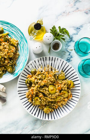 Feder Risotto auf einem Marmortisch mit Gewürzen und Olivenöl Stockfoto