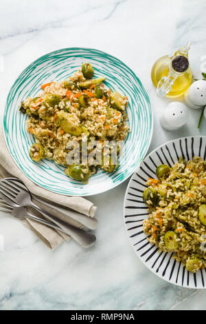 Feder Risotto auf einem Marmortisch mit Gewürzen und Olivenöl Stockfoto