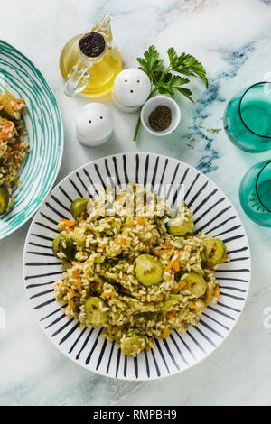 Feder Risotto auf einem Marmortisch mit Gewürzen und Olivenöl Stockfoto