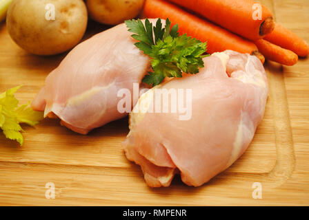 Rohes Huhn ohne Knochen Oberschenkel auf einer hölzernen Schneidebrett Stockfoto