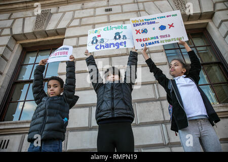 Drei junge Teilnehmer stolz halten Sie Ihre Plakate, die während der Versammlung am Parliament Square. Tausende von der Grundschule, Kinder, Jugendliche und Studenten haben heute aus Unterricht in mehr als 40 Städten und Gemeinden des Vereinigten Königreichs gegen den Klimawandel zu protestieren und die Regierung zum Handeln drängen. Die globale Bewegung wurde von Teenager Aktivistin Greta Thunberg, die Schule schwänzen wurde jeden Freitag seit August außerhalb des schwedischen Parlaments zu protestieren inspiriert worden. Stockfoto