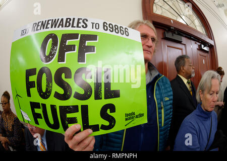 Mineola, New York, USA. 15 Feb, 2019. PHILIP MARINELLI, Huntington, hält ein grünes Schild mit Text Erneuerbare 69866 aus fossilen Brennstoffen, durch Nahrungsmittel und Wasser Action, während NYS Senat Öffentliche Anhörung über Klimawandel, Community and Protection Act Bill S 7253, Sen. Kaminsky, Vorsitzender des Senats Ständigen Ausschusses für Umweltschutz gefördert. Diese 3. Öffentliche Anhörung zum Gesetzesentwurf zur Bekämpfung des Klimawandels wurde auf Long Island. Quelle: Ann Parry/ZUMA Draht/Alamy leben Nachrichten Stockfoto