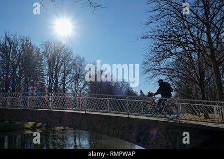 Kassel, Deutschland. 16 Feb, 2019. Bei sonnigem Wetter, einem Radfahrer die Brücke über der Küche Graben in der Karlsaue. Quelle: Uwe Zucchi/dpa/Alamy leben Nachrichten Stockfoto