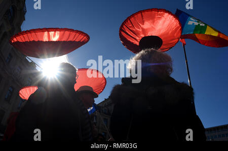 16. Februar 2019, Bayern, München: Demonstranten mit übergroßen Mohnblumen, nehmen an der Demonstration der Aktion Bündnis gegen die Münchner Sicherheitskonferenz. Foto: Angelika Warmuth/dpa Stockfoto